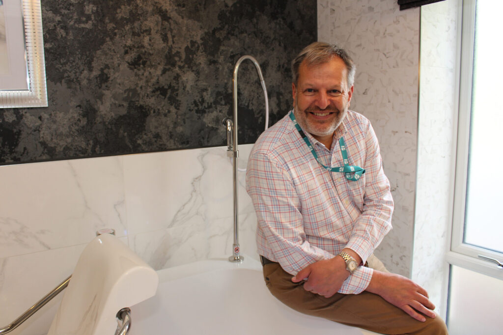 Man sitting on a bath with attached chair