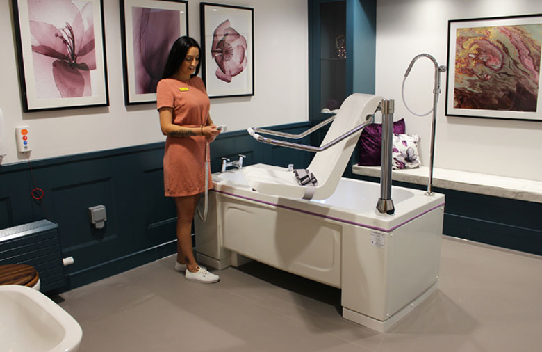 carer-operating-powered-bath-2 carer toilet stand in wet room bathroom