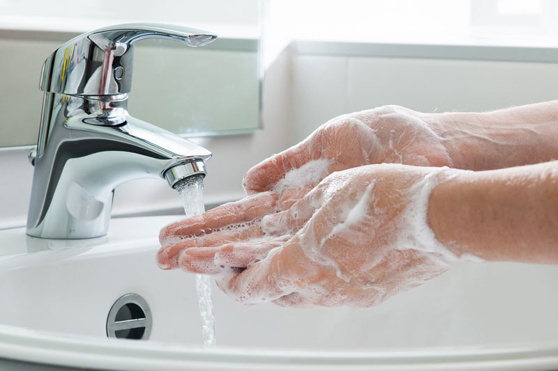 washing hands with soap in sink