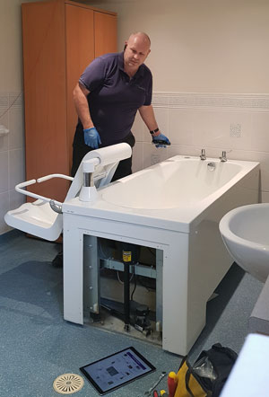 worker manufacturing a bath unit in a walk in bathroom