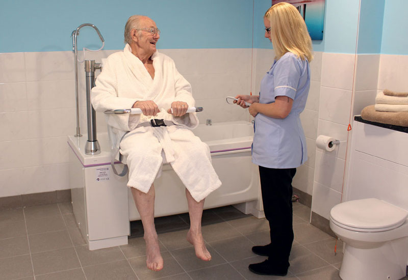 care giver with man in adjustable bath