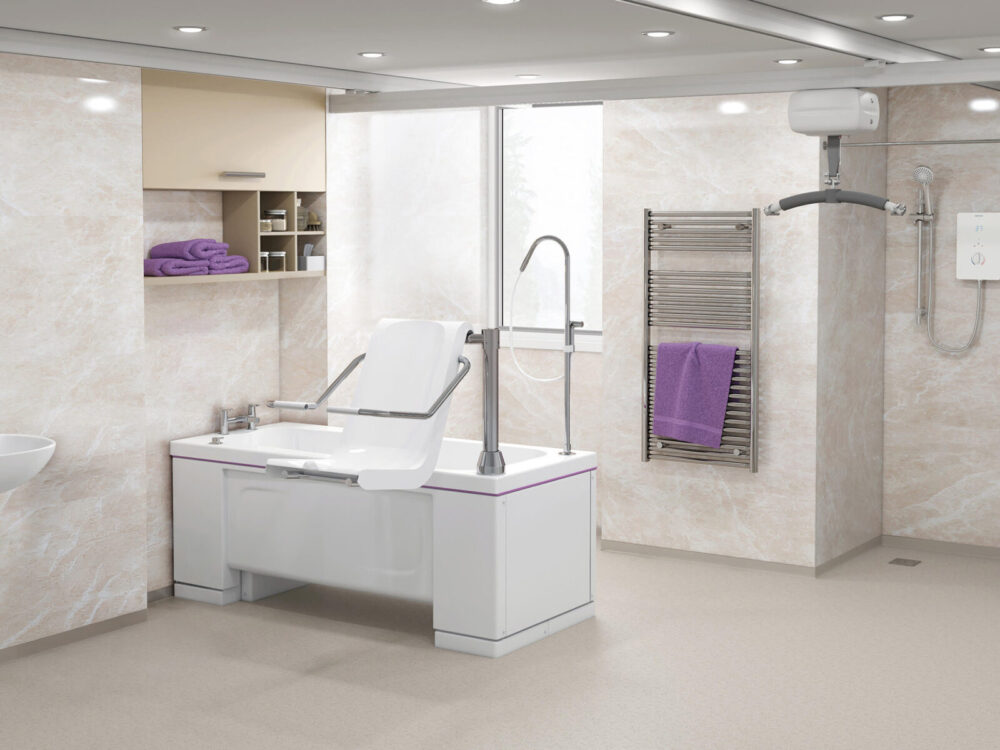 Walk in bathroom with open shower, towel rail, ceiling hoist and bath with a powered rotating bath seat